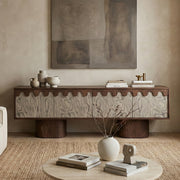 Wooden console table with decorative items in a room with abstract art on the wall.